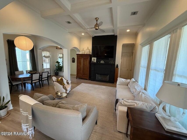 living room featuring beamed ceiling, wood-type flooring, and coffered ceiling