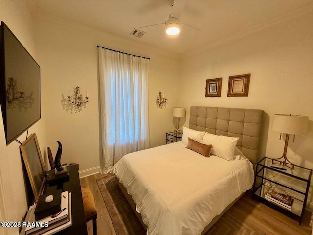 bedroom featuring ceiling fan, ornamental molding, and dark hardwood / wood-style floors