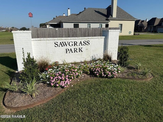 community / neighborhood sign featuring a lawn