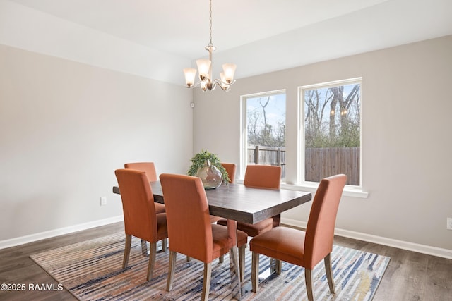 dining area with a chandelier, wood finished floors, and baseboards