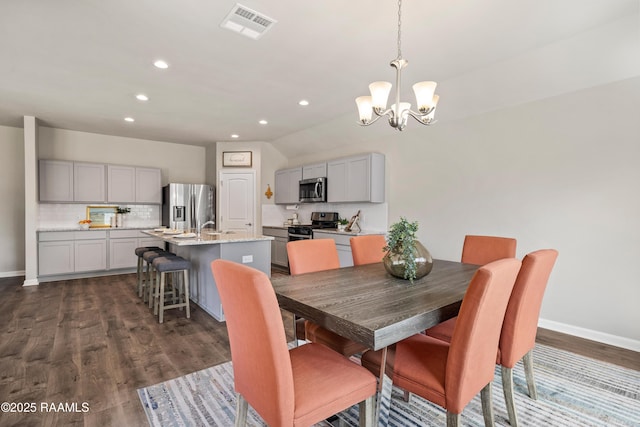 dining area with visible vents, dark wood finished floors, baseboards, and an inviting chandelier