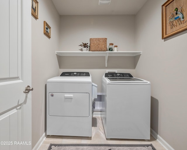 washroom featuring laundry area, baseboards, and washer and dryer