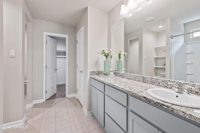 full bath with a walk in closet, visible vents, vanity, tile patterned flooring, and walk in shower