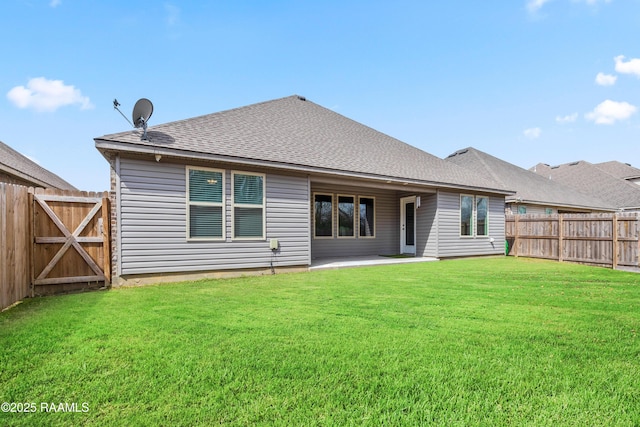 rear view of house with a fenced backyard, a patio, a lawn, and roof with shingles