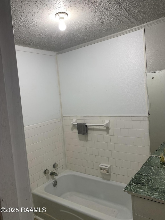 bathroom with vanity, a washtub, and a textured ceiling