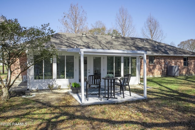 back of house featuring cooling unit, a patio area, and a lawn