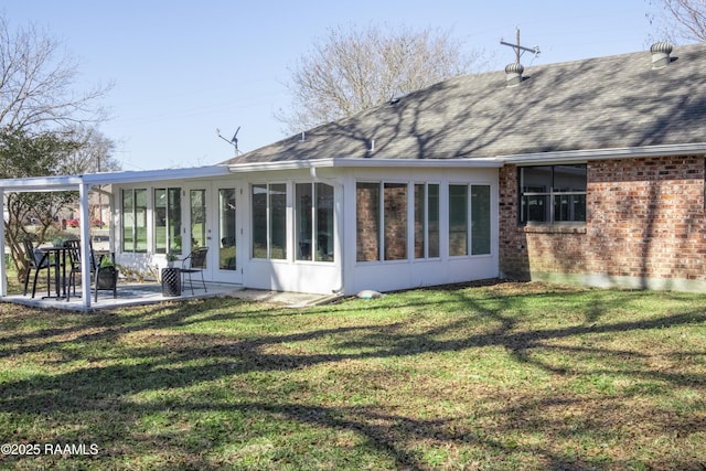 rear view of property with a patio, a sunroom, and a lawn