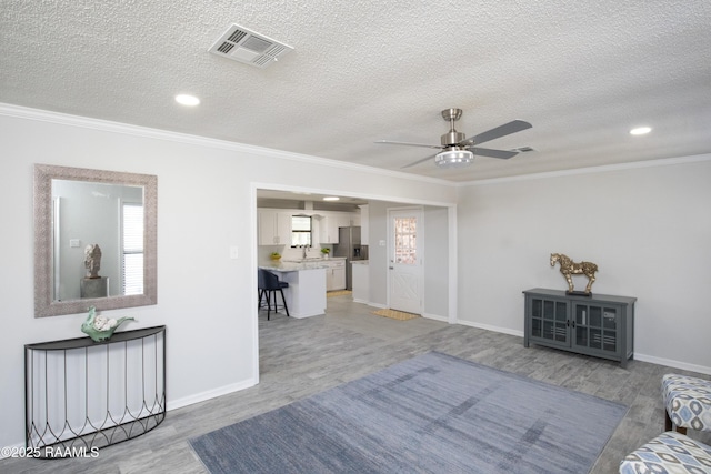 living room featuring crown molding, hardwood / wood-style floors, and a textured ceiling