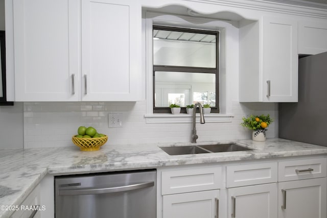 kitchen with sink, white cabinetry, light stone counters, appliances with stainless steel finishes, and decorative backsplash