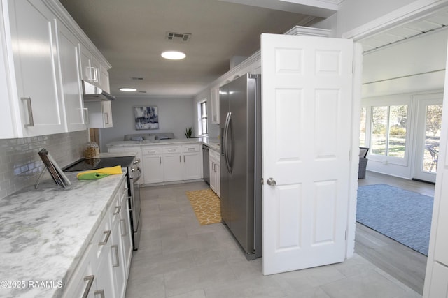 kitchen featuring white cabinetry, light stone countertops, tasteful backsplash, and stainless steel appliances