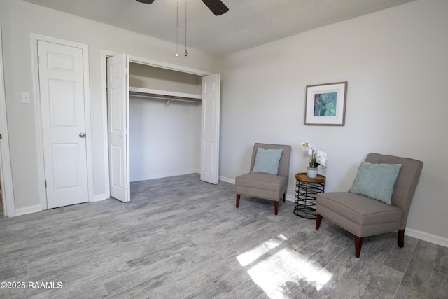 sitting room with ceiling fan and light hardwood / wood-style floors