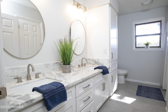 bathroom with vanity, toilet, and a textured ceiling