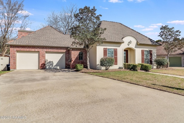 french country style house with a garage and a front yard