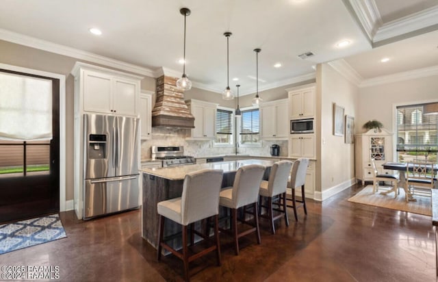 kitchen with hanging light fixtures, a wealth of natural light, a center island, and appliances with stainless steel finishes