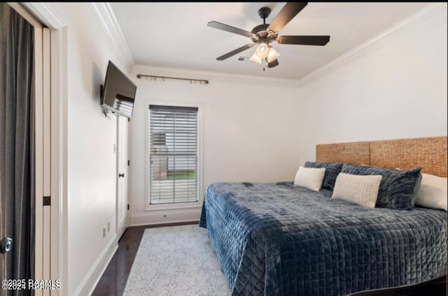 bedroom featuring wood finished floors, a ceiling fan, baseboards, and ornamental molding