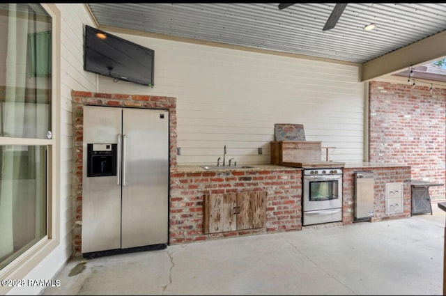 view of patio with ceiling fan, exterior kitchen, and sink