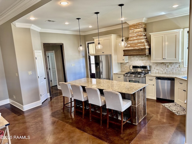 kitchen with a kitchen island, stainless steel appliances, crown molding, decorative backsplash, and baseboards