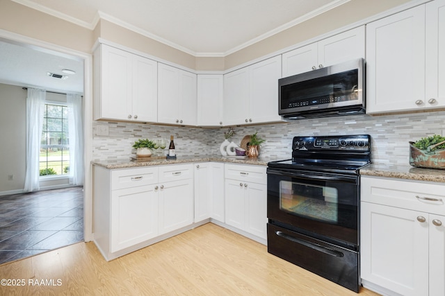 kitchen featuring white cabinetry, black / electric stove, and light wood-type flooring