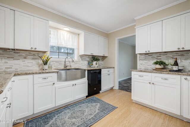 kitchen with light stone countertops, black dishwasher, light hardwood / wood-style flooring, and white cabinets