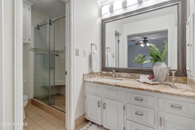 bathroom featuring crown molding, toilet, vanity, and a shower with shower door