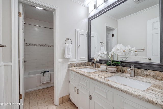 bathroom with tiled shower / bath, vanity, crown molding, tile patterned floors, and a textured ceiling