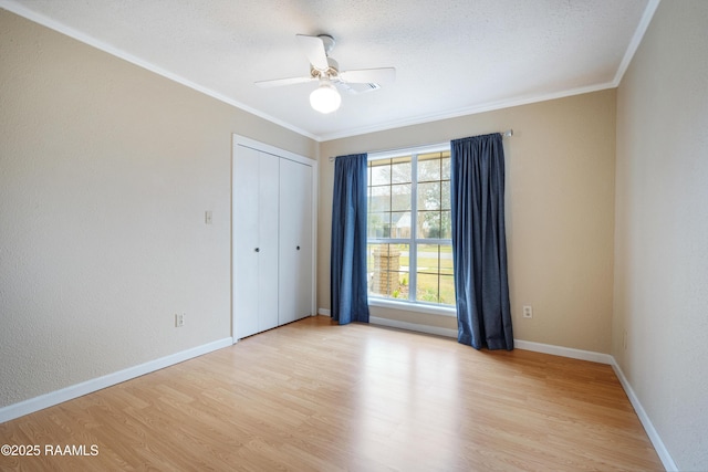 unfurnished bedroom with light hardwood / wood-style flooring, ceiling fan, crown molding, a textured ceiling, and a closet