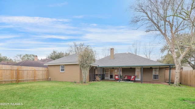 back of property with ceiling fan, a patio area, and a lawn