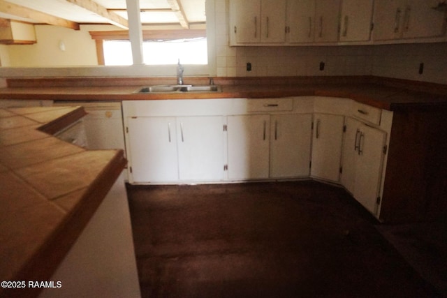 kitchen featuring tasteful backsplash, white cabinetry, white dishwasher, and sink