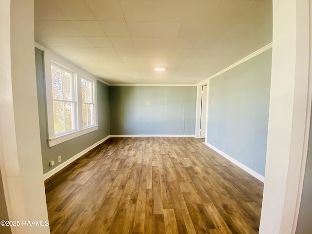 spare room featuring crown molding and wood-type flooring