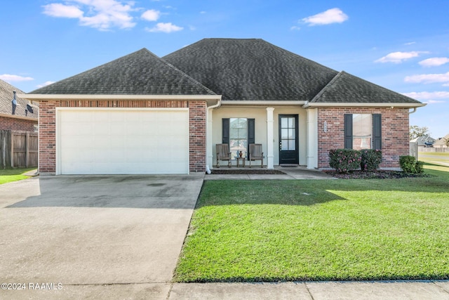 view of front of home with a garage, a front lawn, and a porch