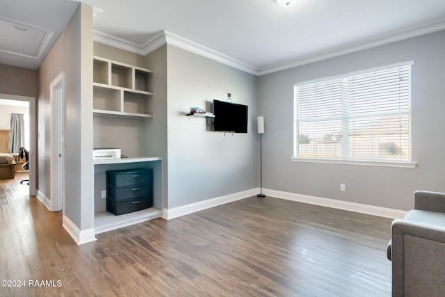 sitting room featuring hardwood / wood-style floors, built in features, and ornamental molding