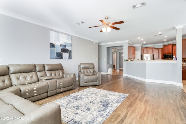 living room with crown molding, light hardwood / wood-style flooring, and ceiling fan