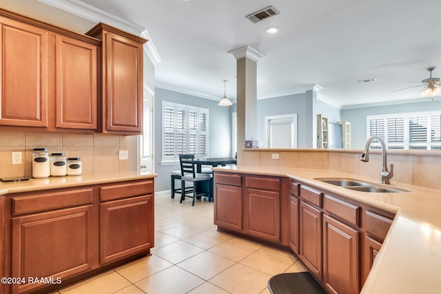 kitchen featuring sink, ornamental molding, decorative backsplash, light tile patterned flooring, and decorative light fixtures