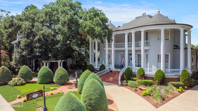 neoclassical / greek revival house featuring a balcony and a front lawn