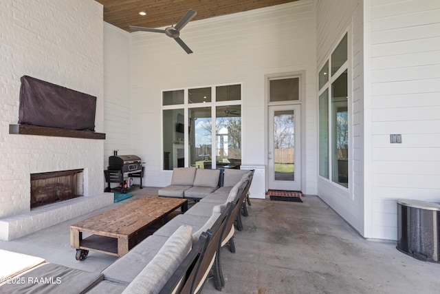 view of patio / terrace with ceiling fan, an outdoor living space with a fireplace, and area for grilling