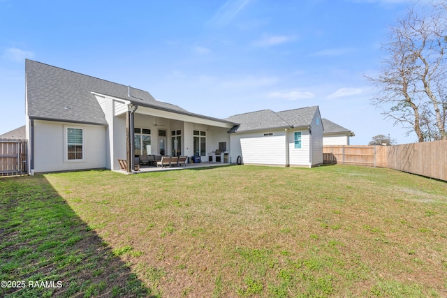 rear view of property with a yard, a patio, and ceiling fan