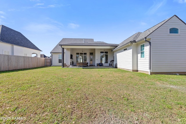 rear view of property featuring a yard, a patio, and ceiling fan