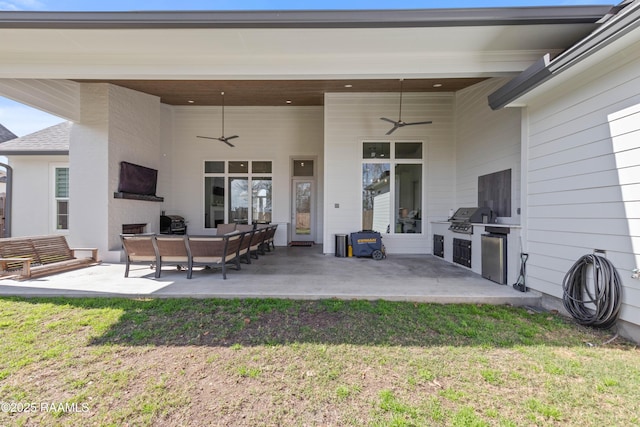 rear view of house with an outdoor kitchen, a yard, ceiling fan, and a patio area