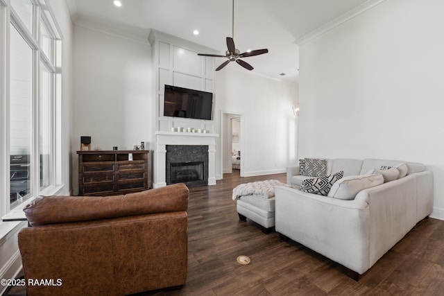 living room with crown molding, a large fireplace, ceiling fan, and dark hardwood / wood-style floors