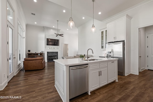 kitchen featuring sink, white cabinetry, decorative light fixtures, a center island with sink, and stainless steel appliances