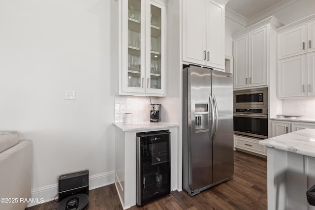 kitchen with appliances with stainless steel finishes, tasteful backsplash, white cabinetry, wine cooler, and light stone counters