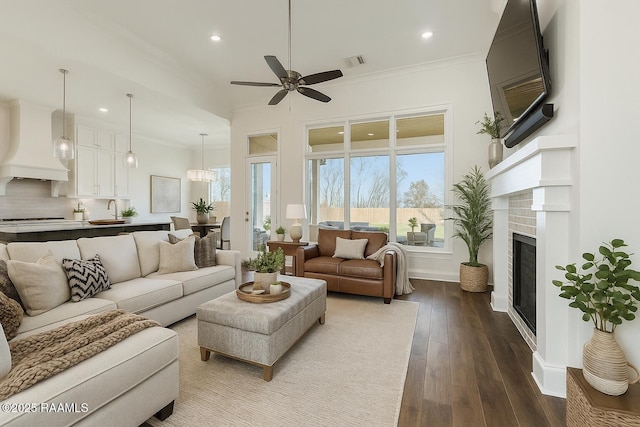 living room featuring a ceiling fan, dark wood-style flooring, recessed lighting, and crown molding