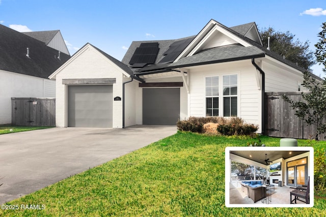 view of front of home with a patio, a garage, ceiling fan, a front yard, and solar panels