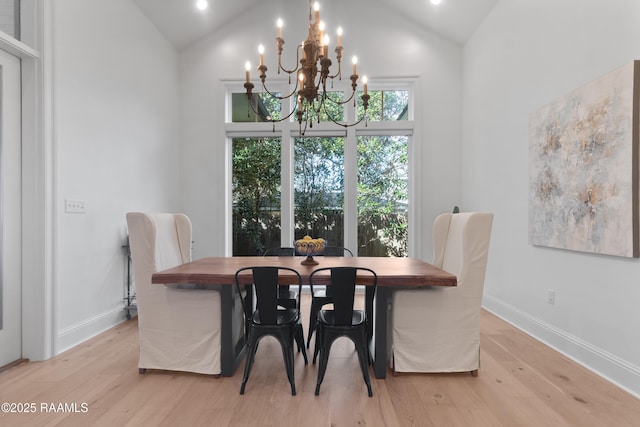 dining space featuring high vaulted ceiling, an inviting chandelier, baseboards, and light wood-style floors