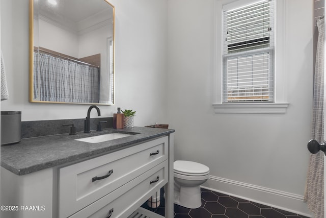 bathroom featuring vanity, a shower with shower curtain, baseboards, crown molding, and toilet