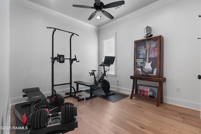 exercise room featuring visible vents, crown molding, baseboards, light wood-style floors, and a ceiling fan