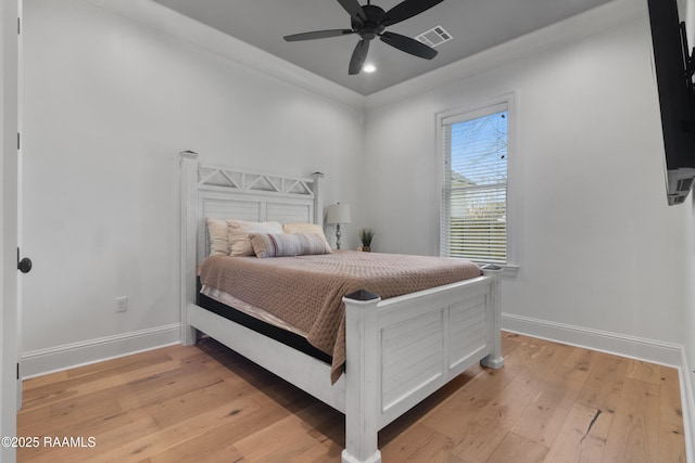 bedroom featuring ceiling fan, ornamental molding, and light wood-type flooring