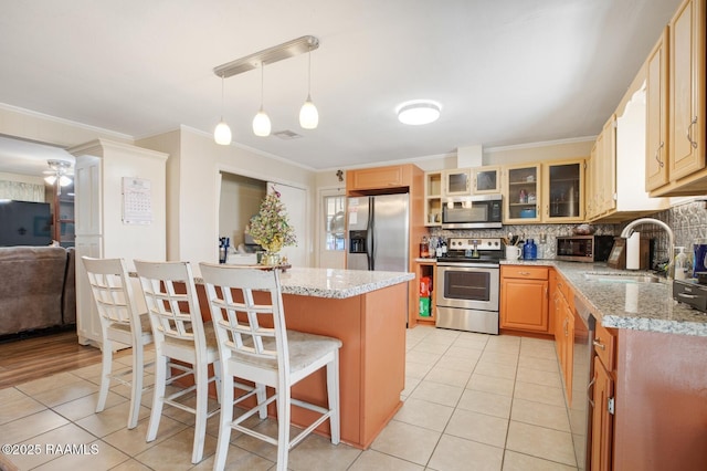 6903 W Congress, Duson, LA 70529 - kitchen featuring stainless steel appliances, ornamental molding, a kitchen bar, light tile patterned flooring, and decorative backsplash