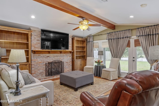 living room with lofted ceiling with beams, ceiling fan, wood finished floors, french doors, and a brick fireplace