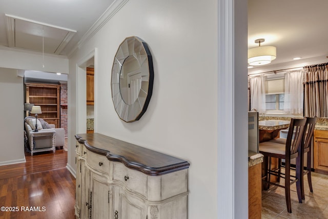 hall with attic access, ornamental molding, baseboards, and wood finished floors